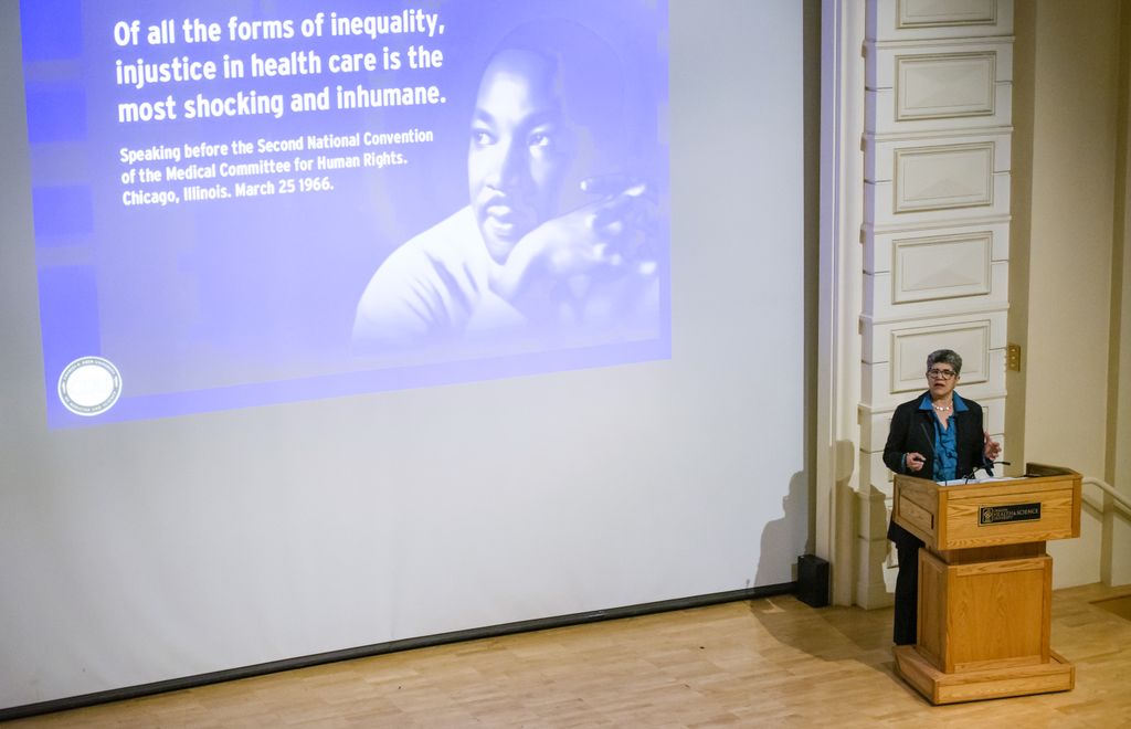 image of martin luther king on large presentation screen on the left, with a speaker at a podium on the right