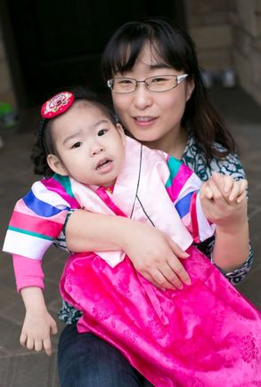 young girl in korean cultural clothing, with her mother