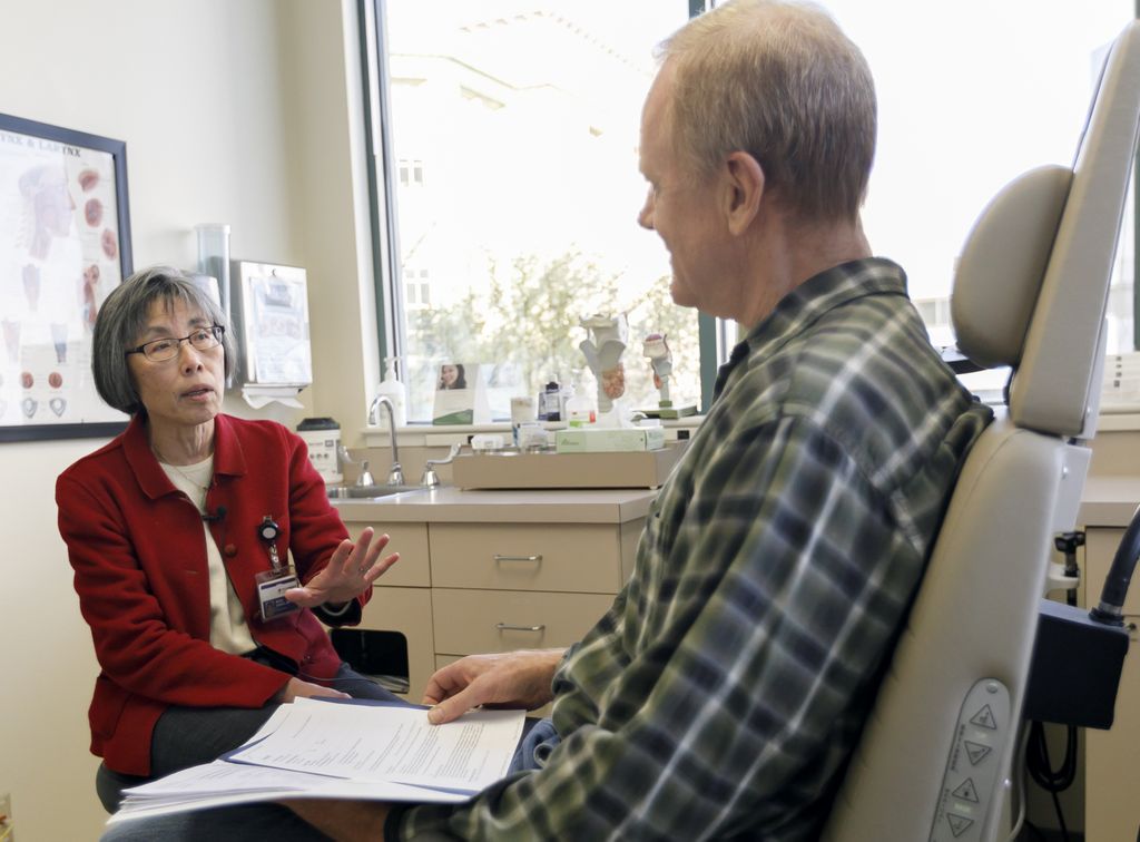 doctor talks with a patient in an exam room