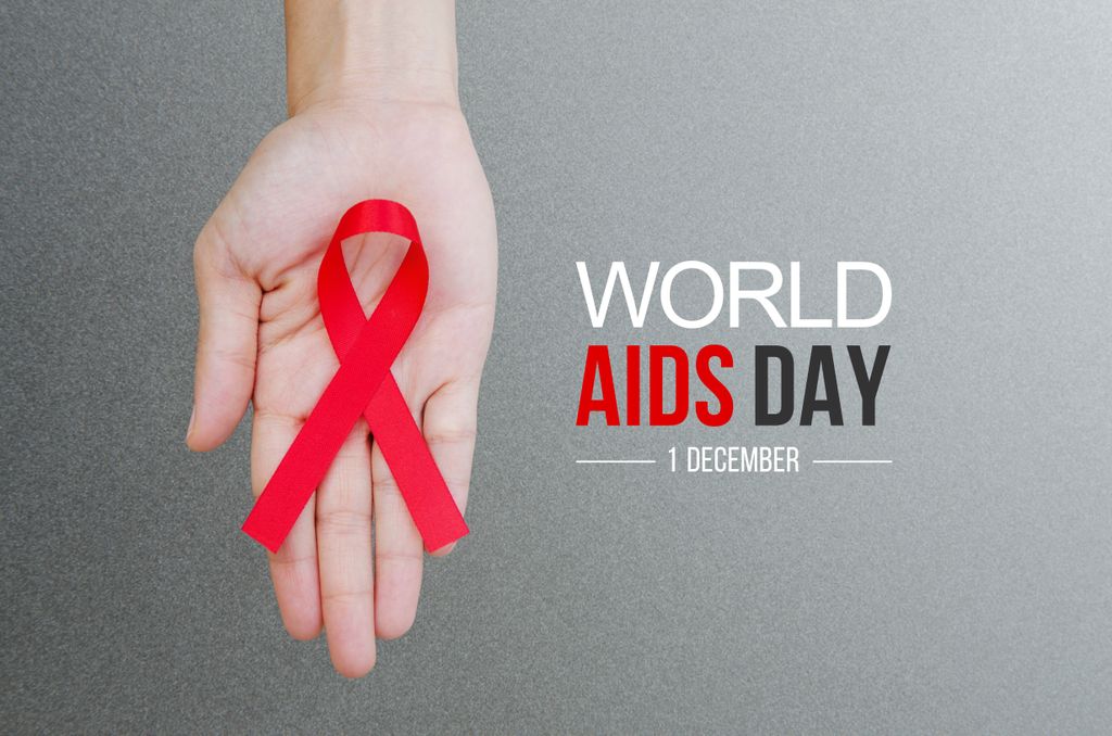 hand holding a red ribbon for World Aids day