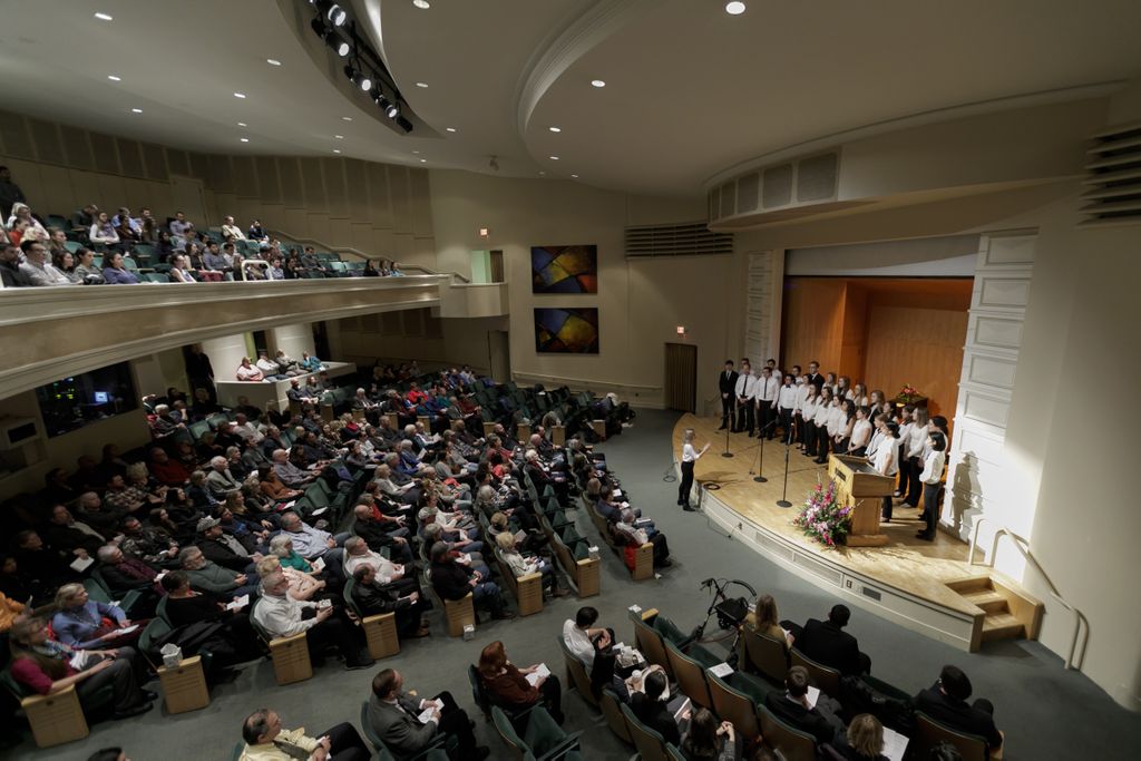 photo of a stage, with singers visible as well as the audience