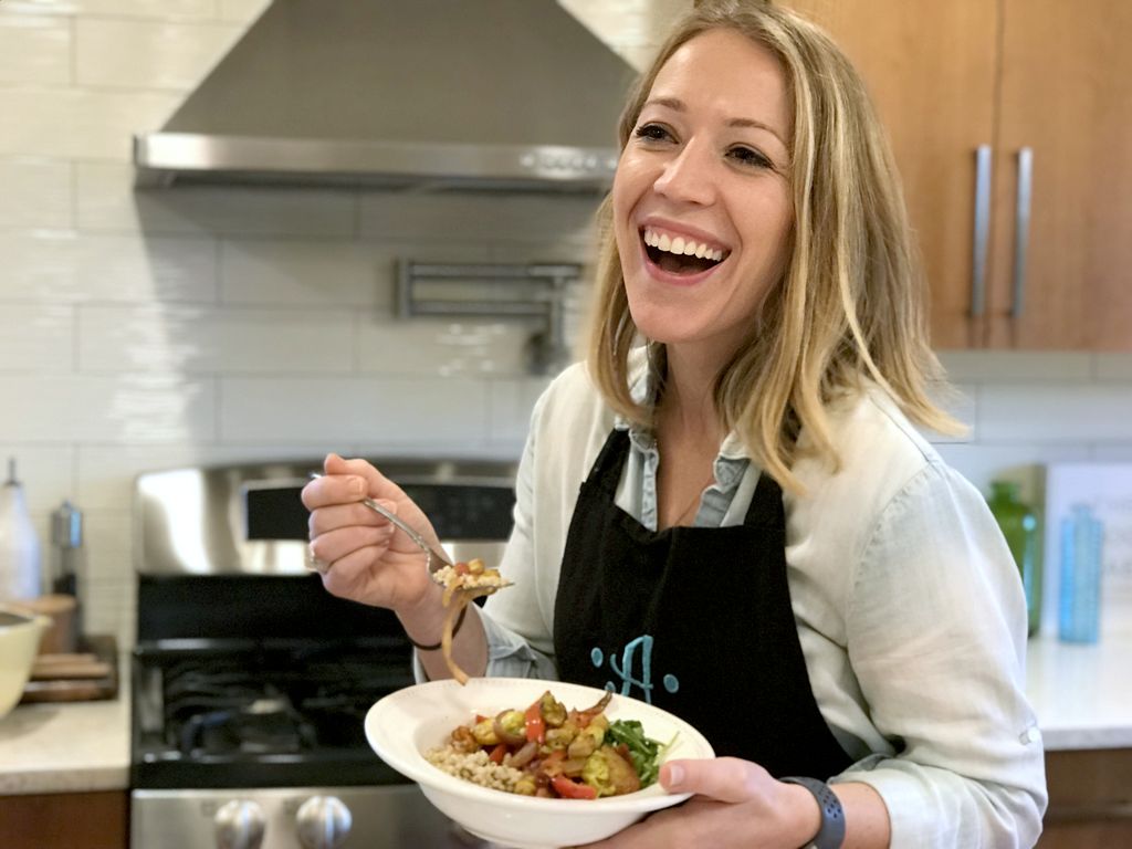 bryant, holding a bowl of vegetables and laughing