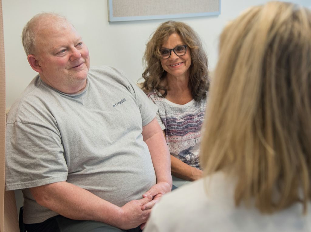 man and woman talking with doctor