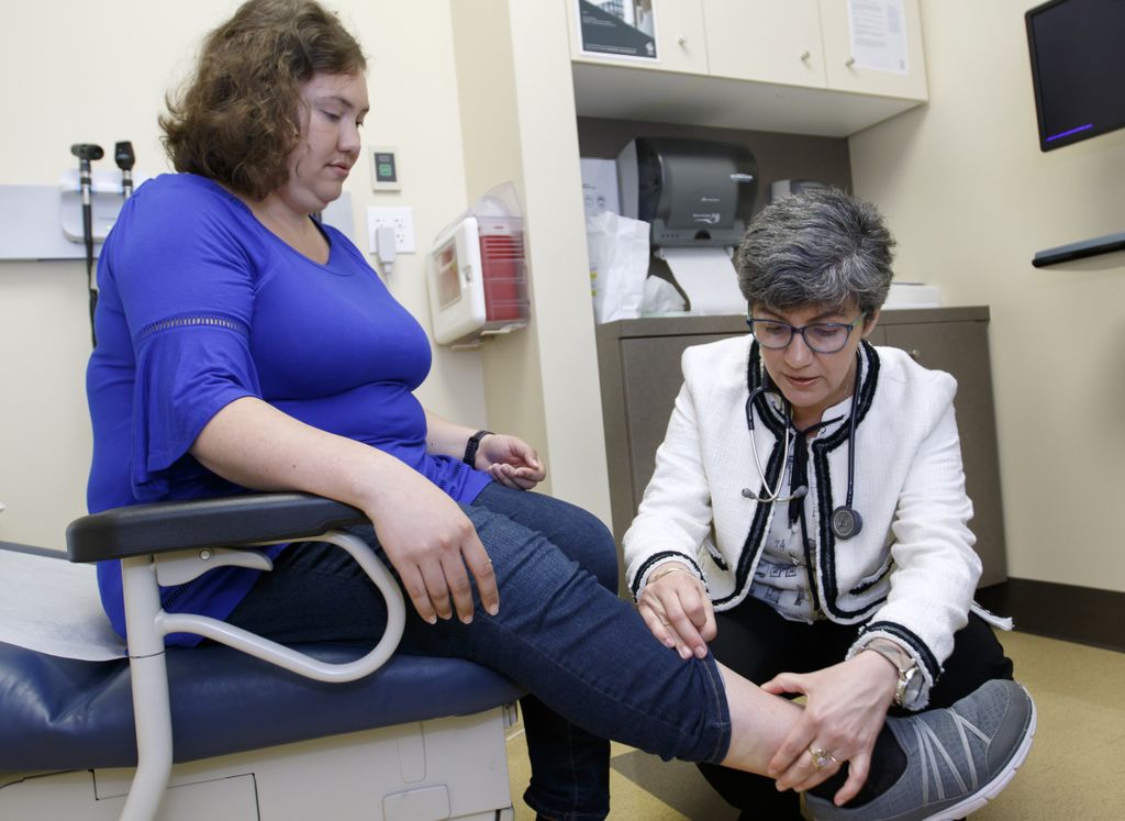 doctor examining legs of patient