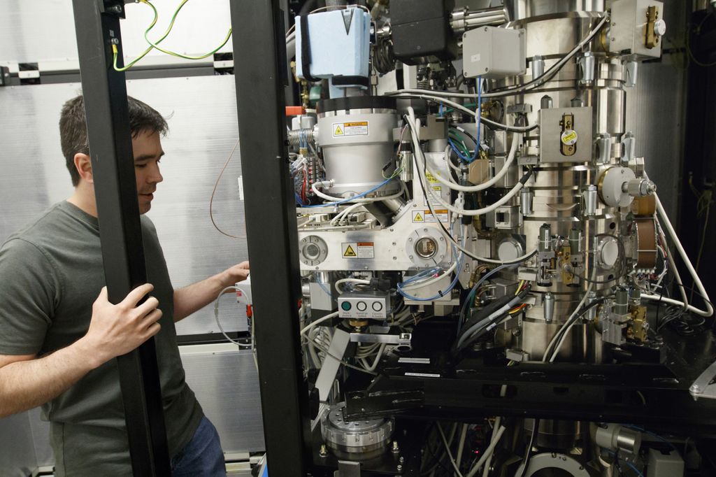 man on left side of image, looking into giant cryo-em microscope