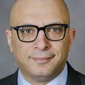 Ahmed Raslan, M.D. smiles against a medium-gray background.