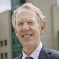 Image of John Hunter, M.D., FACS, at OHSU. A man standing outside OHSU hospital wearing a suit.