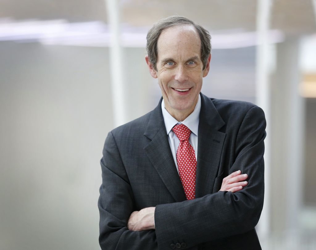 portrait of brian druker, wearing a suit with arms crossed