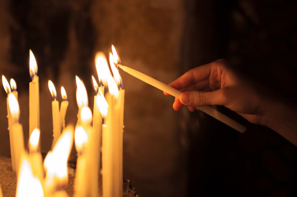 closeup of hand lighting candles