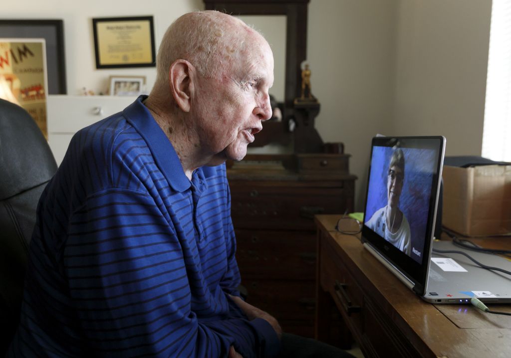 bald, older man chatting with someone via video