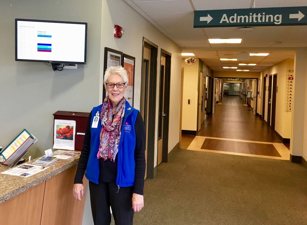 older woman standing near welcome counter in hospital