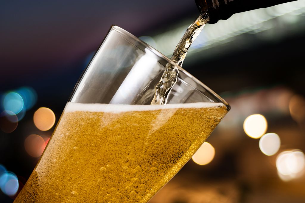 bottle pouring beer into a glass
