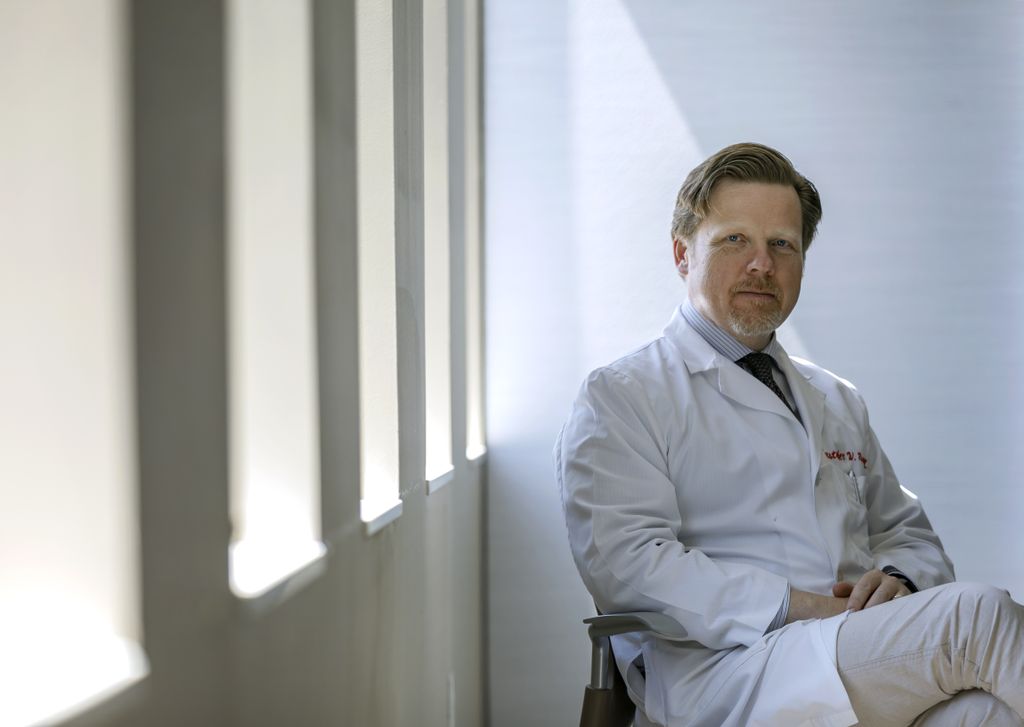 Christopher Ryan, sitting and looking directly at a camera