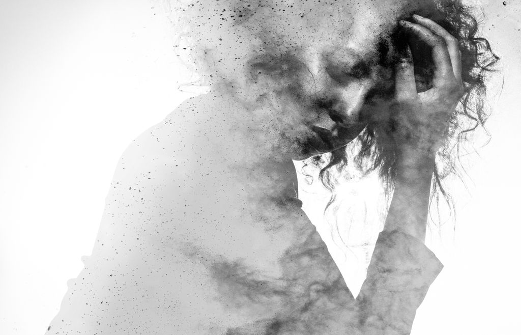 pen ink drawing of unhappy woman, double image, paint splattered and disappearing, with head in hand