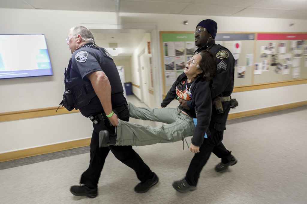 two police officers carry a woman between them