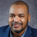Close-in headshot of Anthony Deloney, a smiling Black man with a goatee in a suit