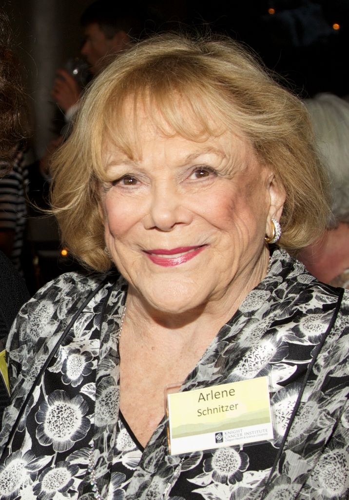older woman with blond hair, smiling at camera