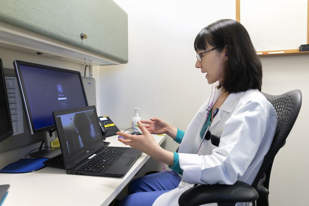 A doctor talks with her patient through video chat on her computer at OHSU.