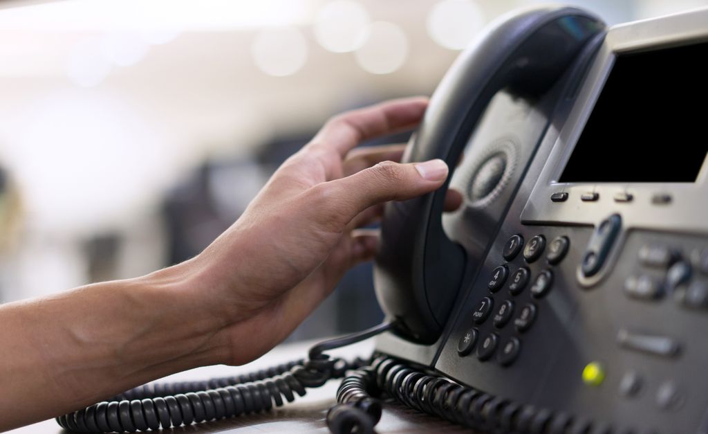 close up shot of a hand grabbing a phone