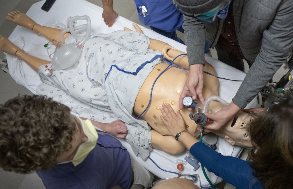 overhead view of a lifelike human body with people standing around