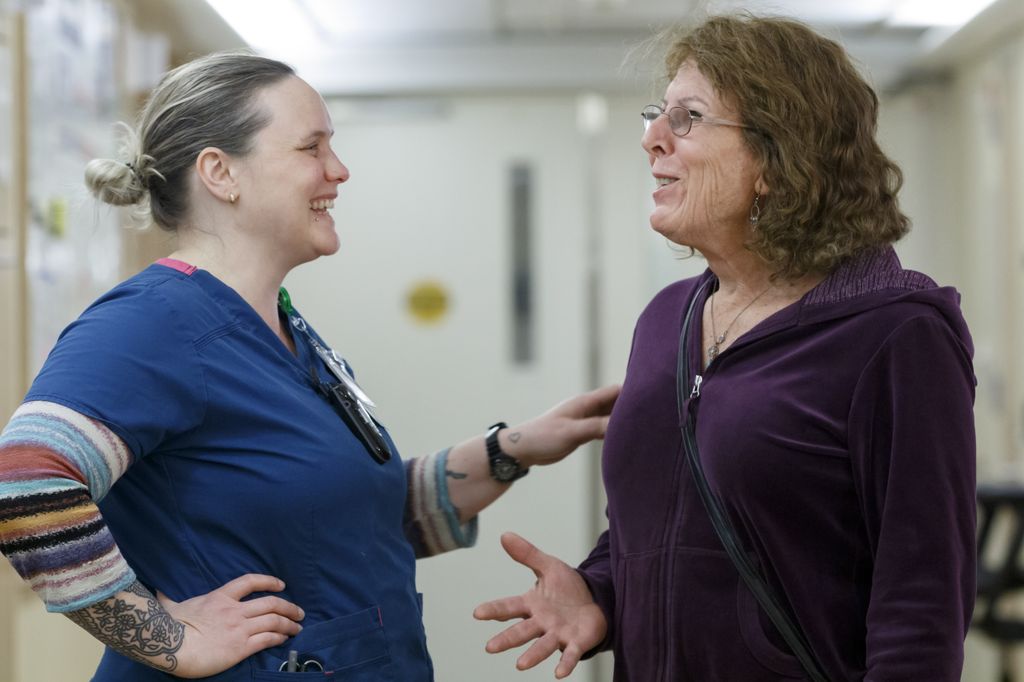 two woman laughing together in a hospital hallway