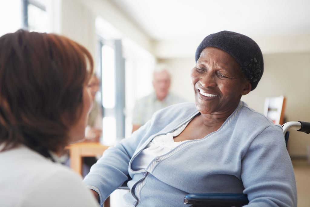 african american woman smiling, looking at another person who is seen from the back