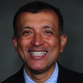Headshot of Akram Khan, M.D., a smiling man with short, dark hair in a suit.