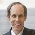 Brian Druker, M.D. stands near a building.