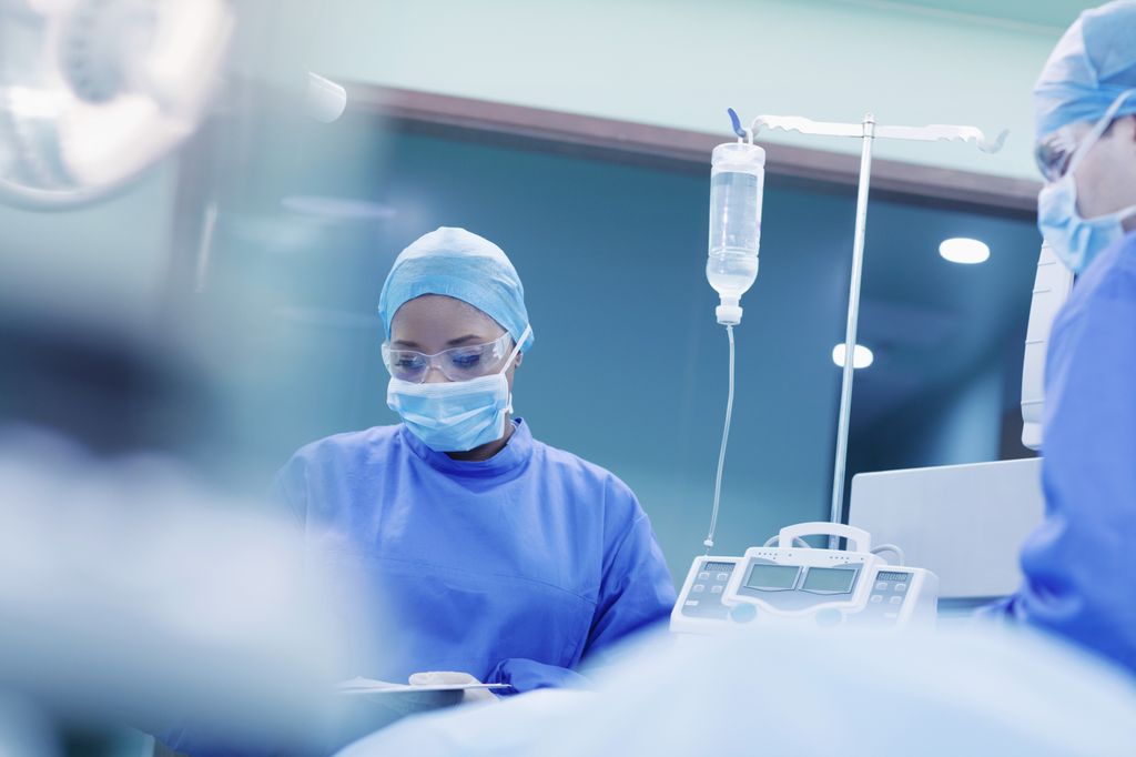 Photo shows two clinicians wearing procedure masks preparing for a surgery.