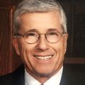 Man wearing glasses in a suit.