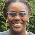 Close-in headshot of Nichole Watson, a Black woman smiling wearing glasses