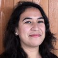 An image of Gladys Rivera, One Community Health's director of preventive health. A woman with dark wavy hair smiling.