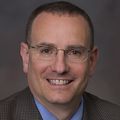 Martin Schreiber, M.D. poses with a brown background.