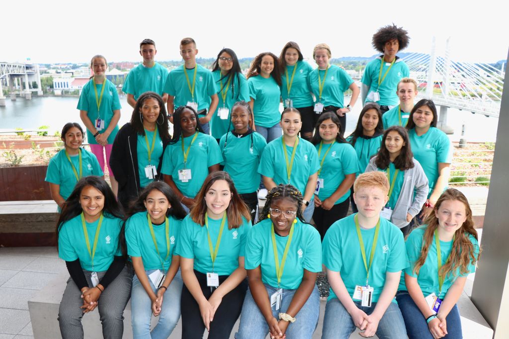 Knight Scholars group photo: three rows of students in matching teal t-shirts look at the camera
