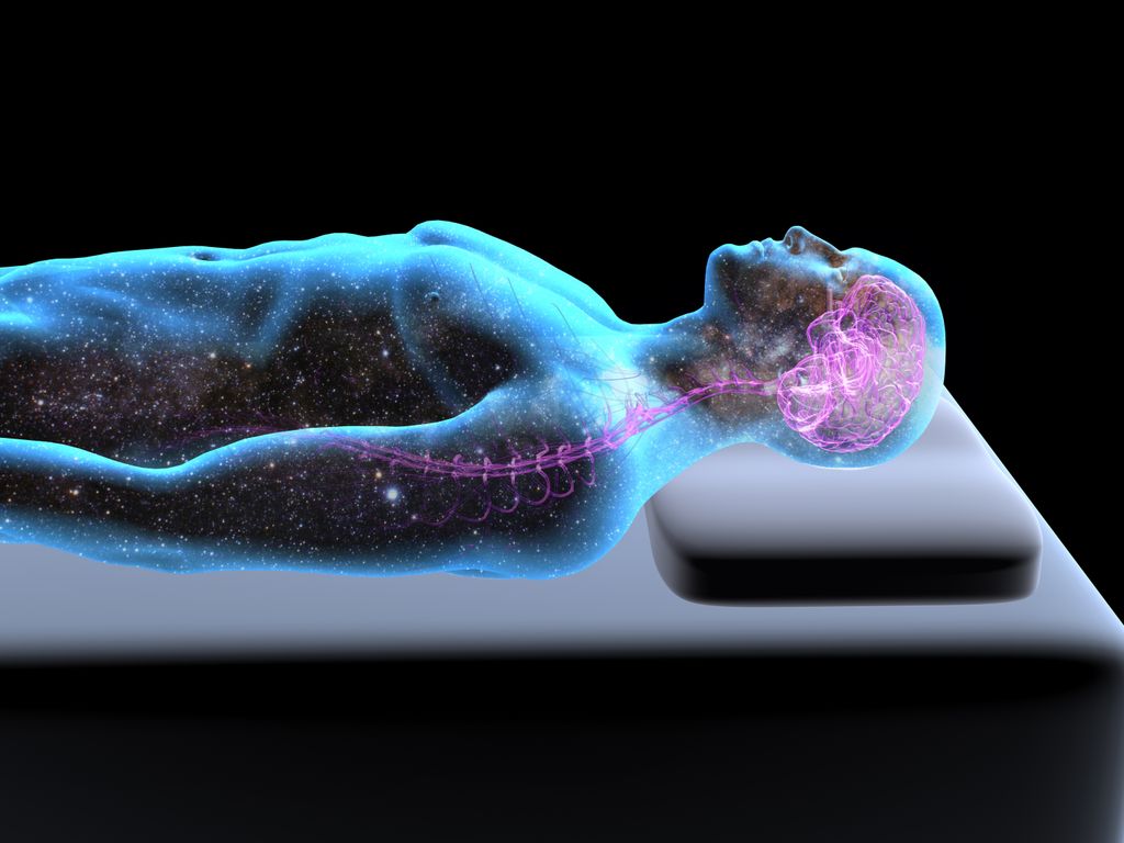 Side view of reclining, sleeping man on a bed, body filled with star field, pink illuminated brain, x-ray style, black background.