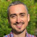 Headshot of Chris Stauffer, M.D., a smiling man with short hair and a beard in front of greenery