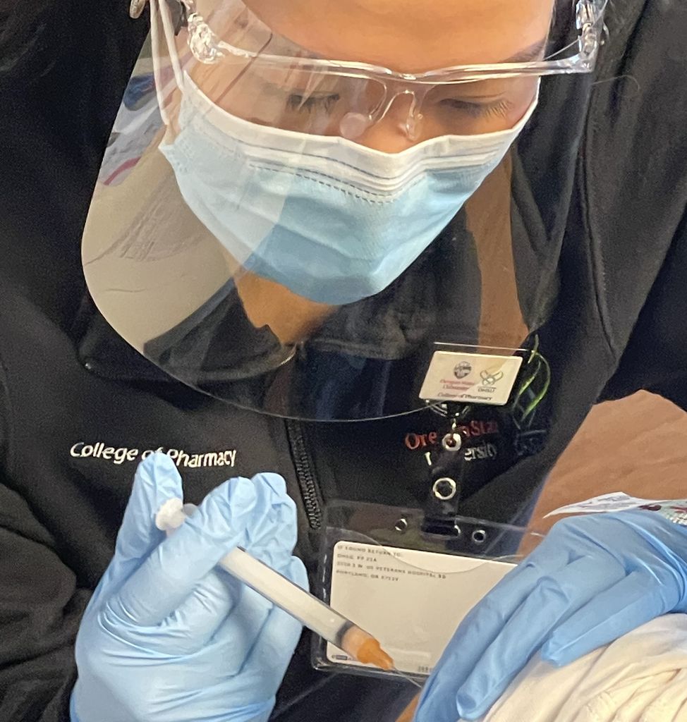 Close-up of female pharmacy student injecting a vaccine. (Patient is not pictured.)