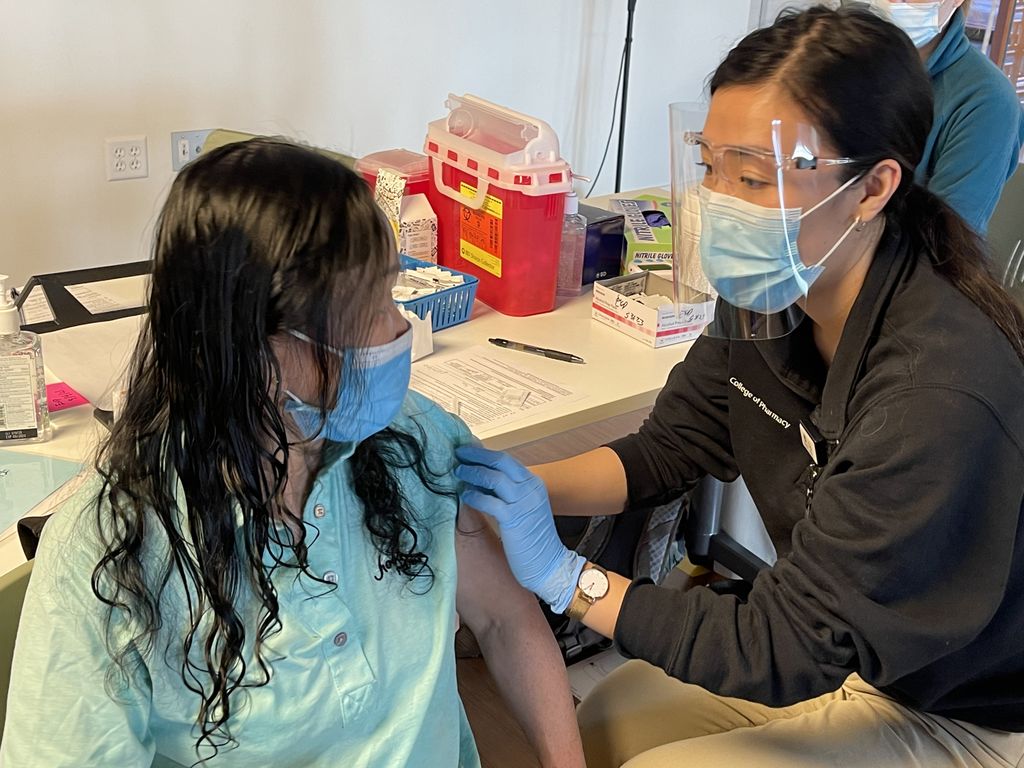 Asian Health & Service Center vaccinations. A man getting a COVID-19 vaccine by OHSU staff.