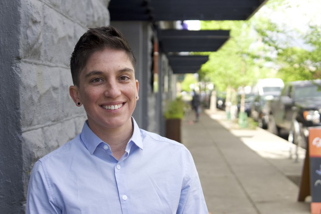 Jae Downing, Ph.D., stands on a sidewalk.