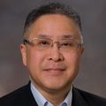 Close-in headshot of Paul Leung M.D., a smiling Asian man wearing glasses