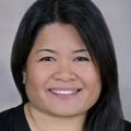 Head shot of Judith Guzman-Cottrill, D.O., a smiling Asian woman with long, black hair