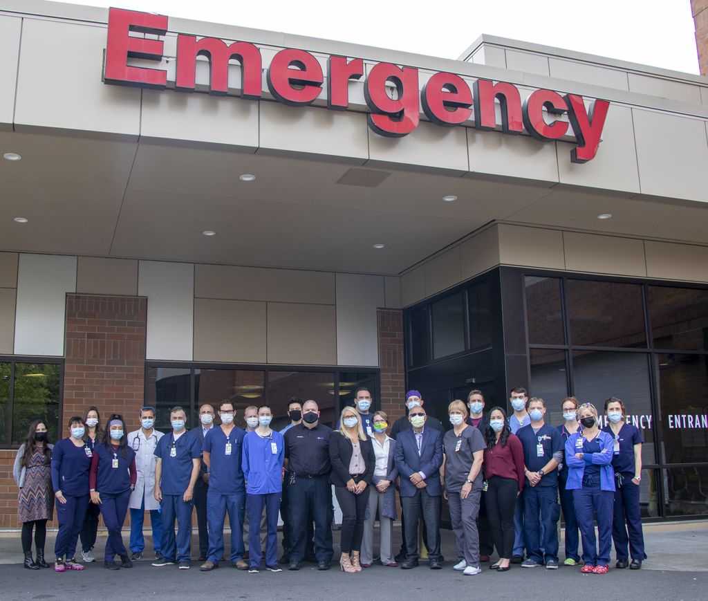 A large group of healthcare and research team members stands outside the Adventist Health Portland Emergency Department.