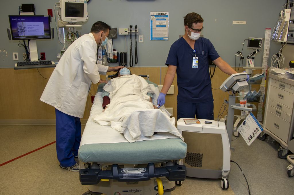 A doctor and a nurse practice attending to a patient (played by a co-worker nurse) in a bed at Adventist Health Portland hospital.