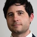 Portrait of Sky Ferrara, Ph.D., a short-haired, brunette adult in a suit and tie.