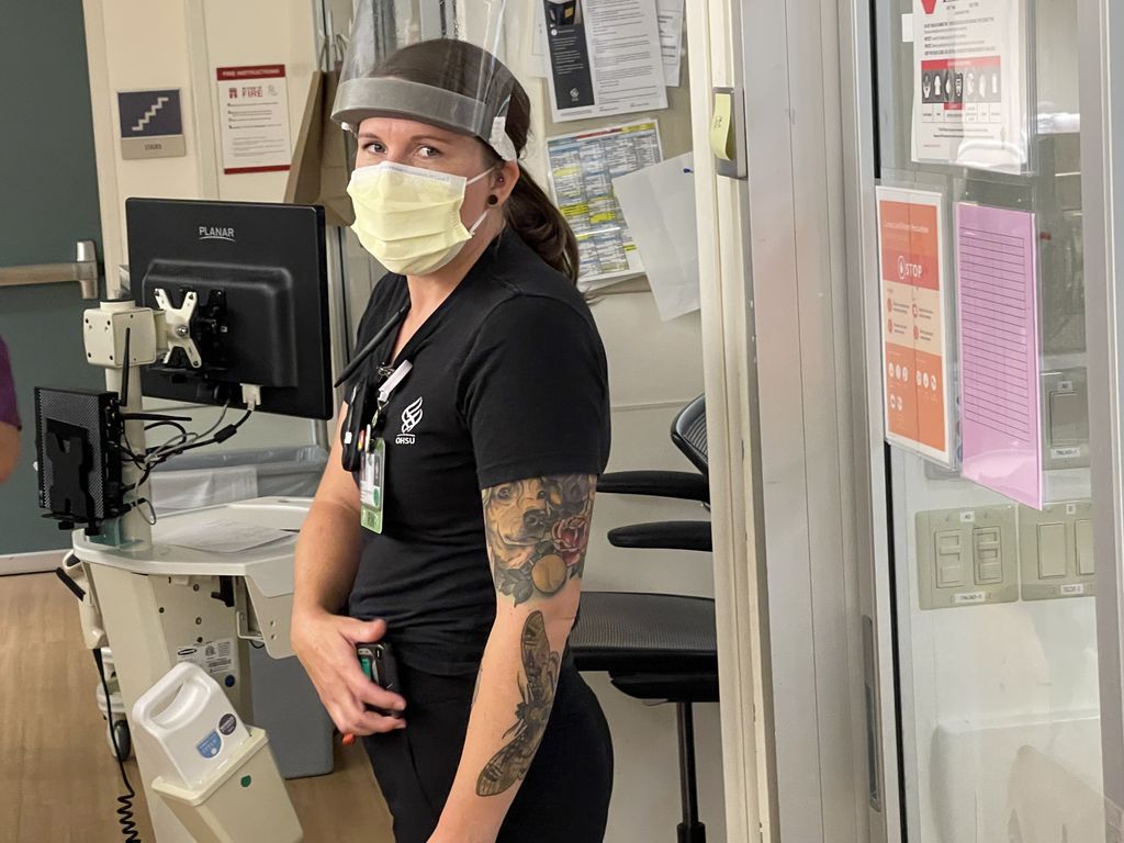 Nurse standing outside a patient’s room in the ICU.