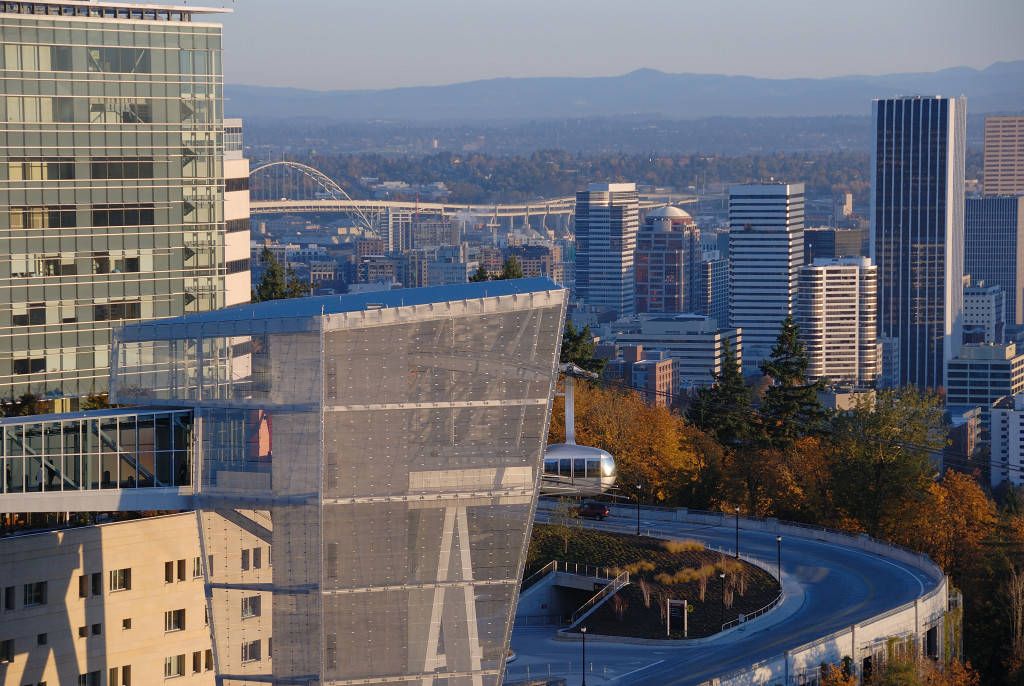 The OHSU sky tram can be seen with the city of Portland and mountains in the background.