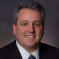 David Robinson, Ph.D. (OHSU) A man with dark gray hair with a suit and tie, smiling.
