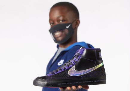 OHSU Doernbecher Freestyle 2022 - a boy age 13 holding a purple and black shoe.