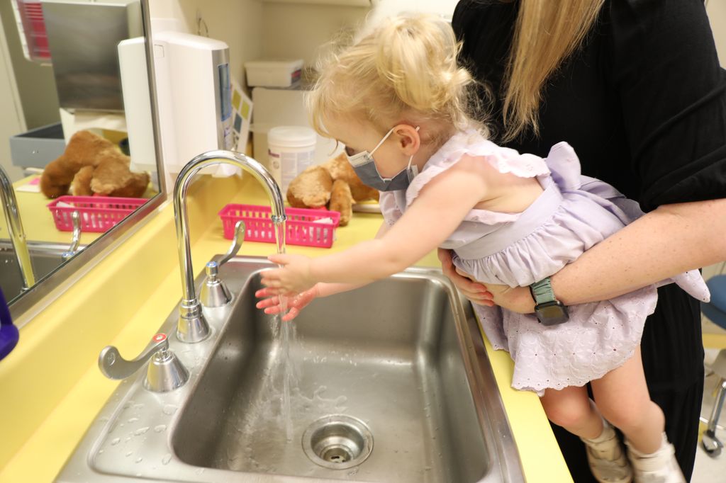 Josephine "JoJo" Schmidt, 2, washes her hands after receiving her COVID-19 vaccine. Frequent hand washing, staying up to date on vaccines, and avoiding people who are sick are all ways to help prevent the spread of RSV. (OHSU/Christine Torres Hicks)