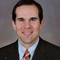 Matt Hansen M.D., M.C.R. (OHSU) A person with short dark hair in a suit, smiling.